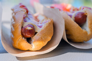 Hot dogs with mustard and ketchup wrapped in paper.