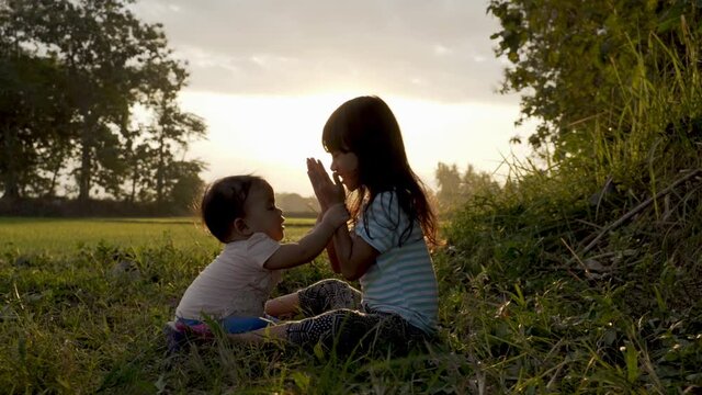 cute sister baby playing outdoor togehter on beautiful sunset