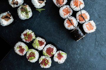 Set of rolls and sushi. Rolls and sushi on a dark brown board. Rolls with red caviar, with salmon, with tuna.  © Vladimir