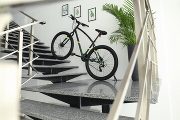 Modern black bicycle on stairs at home