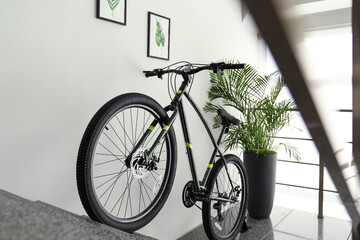 Modern black bicycle on stairs at home