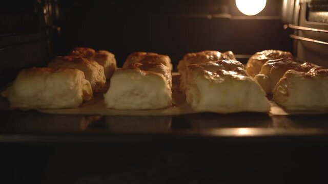 Dessert buns with apples in the oven, homemade pastries from puff pastry French. French pastry. Delicious apple buns baked in the oven. Fresh homemade bread in oven.