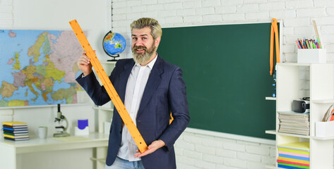 Handsome bearded man in classroom chalkboard. Modern teaching method. Each School defines final...