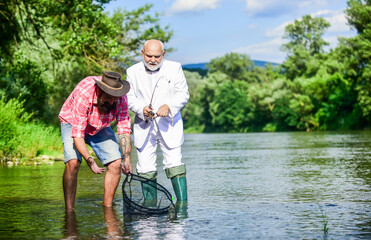 Fish trapped in net. Oh happy day. Fishing team. Family day. Hobby and recreation. Freshwater fish. Bearded man and brutal hipster fishing. Catching fish with soulmate. Friends catching fish