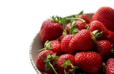 Fresh ripe organic strawberry close up in a bowl isolated on white background. Organic fruit diet. Healthy vegetarian nutrition