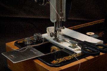 Sewing machine and parts on a dark background.