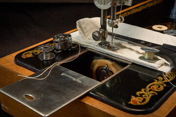 Sewing machine and parts on a dark background.