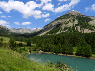 Fototapeta na wymiar Lac d'Estenc à Entraunes et montagnes verdoyantes dans le Parc National du Mercantour
