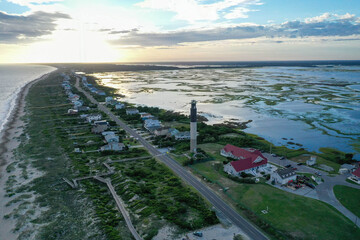 Looking down the coastline and waterway with the Oak Island Lighthouse in view. Sun setting behind...