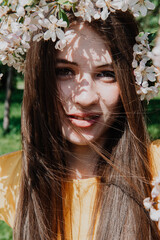 young woman with brown hair among Apple blossoms, smile