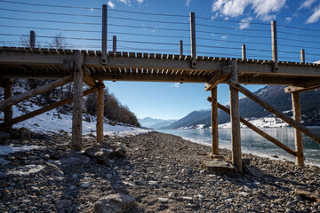 Fototapeta na wymiar wooden bridge over the sea.Reschensee.