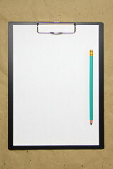 A tablet with a white sheet of A4 format on a beige craft paper.