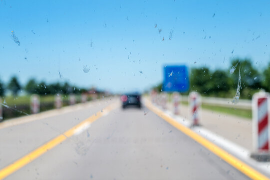 Reste von Insekten als Sichtbehinderung auf der Windschutzscheibe eines Autos auf der Autobahn