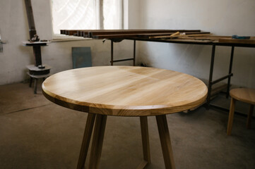 Brown, light brown wooden round dining table. Modern designer, dining table on dark background