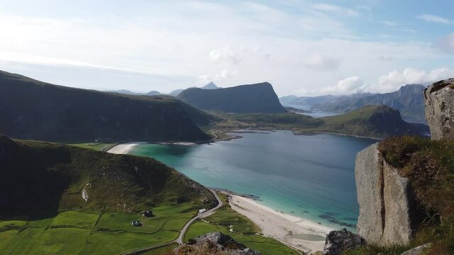 View from mountain Mannen over Haukland beach in Lofoten, Norway during a sunny summer day. Turquoise and blue ocean meeting the white sand beach with the fjords in the background.