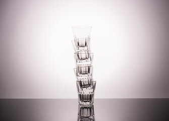 empty vodka glasses are built like a skyscraper with a beautiful gradient background