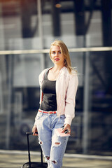 Girl in a airport. Blonde with a documents. Lady in a black t-shirt