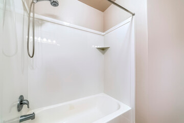 Close up of bathroom bathtub with stainless steel shower head and faucet