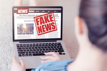 Yang woman read fake news on a laptop screen. Mockup website. Newspaper and portal on internet....