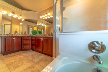 Bathroom interior with marble countertop brown wood cabinets and large mirrors