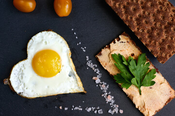 fried eggs with bread on a black background