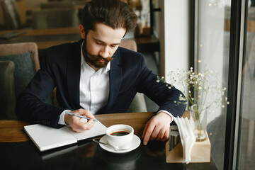 Handsome man in a black suit. Businessman working in a office