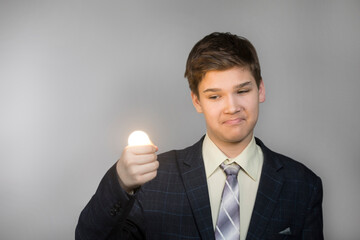 Teenager with a light bulb in his hand found a great idea