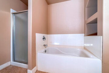 Bathtub and shower stall with frosted door inside bathroom with tile floor