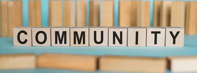 Community word written on wood block. Community text on blue table with wood background for your desing, concept.