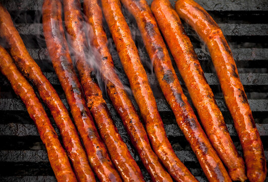 Grilled Smoked Sausages Overhead Vibrant Color Outdoor Close Up Arrangement With Grill Marks On Black Metal Grate Barbecue Colorful Outdoor