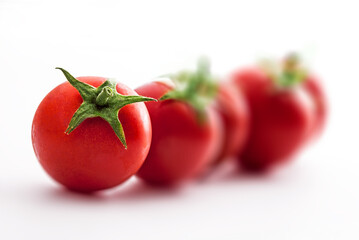 Tomatoes fresh colorful isolated selective focus arrangement stacked on white background in studio