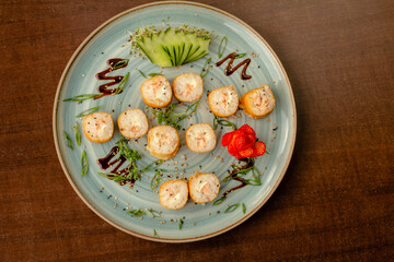 Prato com hot roll de salmão, decorado com pepino e morango
