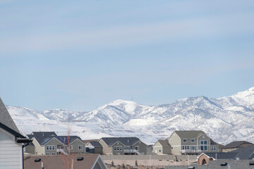 Neighborhood in South Jordan City against snowy Wasatch Mountains and cloudy sky