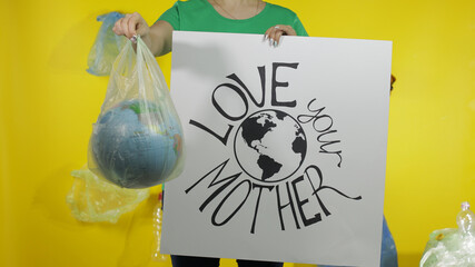 Unrecognizable woman with protesting poster and Earth globe in plastic package. Ecology pollution