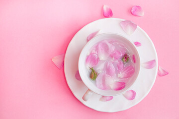 tea of flowers and rose petals on a delicate background, a drink of roses, the concept of tenderness and freshness