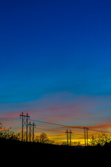Fototapeta na wymiar Electricity posts silhouetted against blue sky in Provo Canyon Utah at sunset
