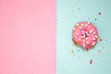 sweet tasty donut with icing and sugar on a pink background with place for text.