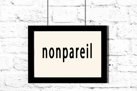 Black frame hanging on white brick wall with inscription nonpareil