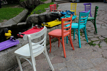 colorful chairs by a small city pond