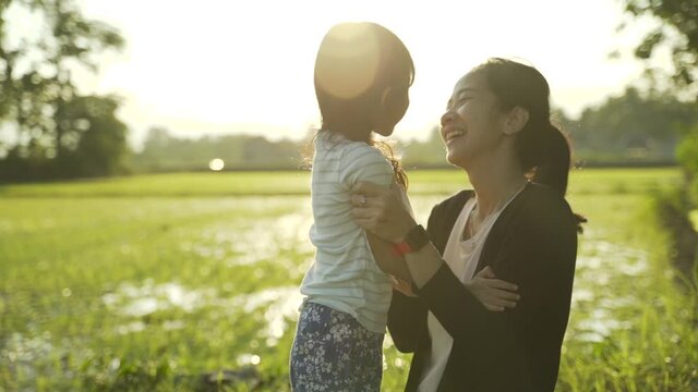 asian mother and daughter enjoy playing outdoor in the field