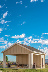 Building with attached picnic pavilion at a park against mountain and blue sky