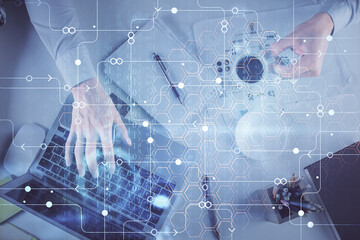 Double exposure of man's hands typing over computer keyboard and data theme hologram drawing. Top view. Technology concept.