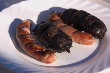 Closeup of a plate with sausages cooked on the grill