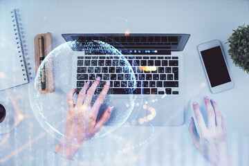 Double exposure of woman hands working on computer and world map hologram drawing. Top View. International business concept.