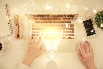 Double exposure of woman hands working on computer and social network theme hologram drawing. Top...