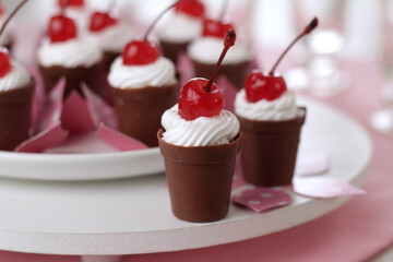 chocolate cups with cream and cherry