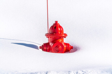 Vibrant red fire hydrant buried in snow during winter in Park City Utah
