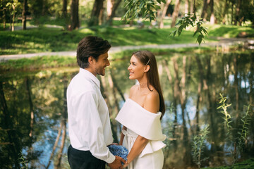 Fototapeta premium Happy Wedding Couple Saying Vows Holding Hands Standing In Park
