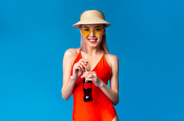 Summer Beverage. Happy young girl in swimsuit enjoying sweet refreshing drink