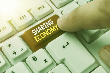 Conceptual hand writing showing Sharing Economy. Concept meaning a system where assets are shared...